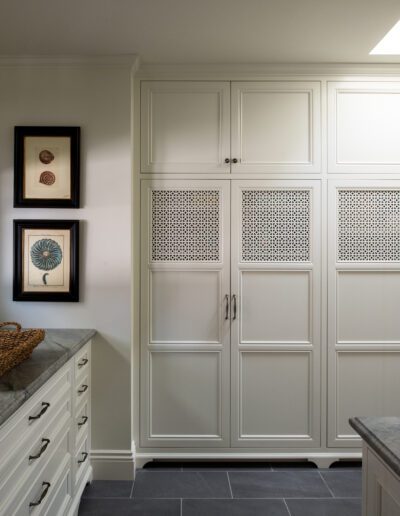 A white kitchen with white cabinets and black counter tops.