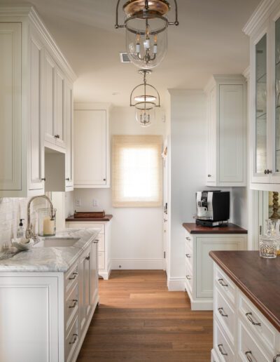 A kitchen with white cabinets and a wine cooler.