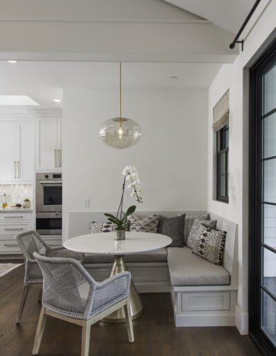 A white kitchen with a dining table and chairs.