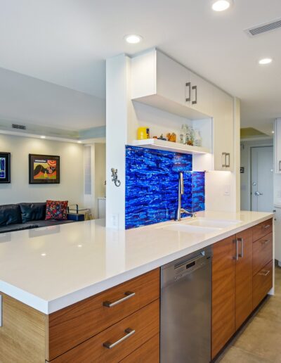 A white kitchen with a blue backsplash.