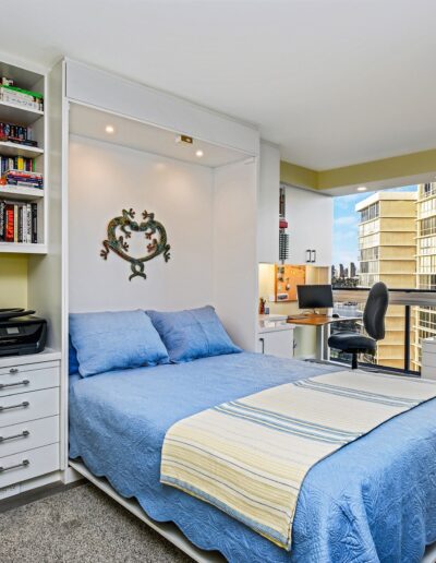 A bedroom with a bed and a desk.