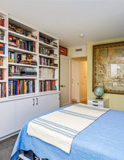 A bedroom with a bed and bookshelves.